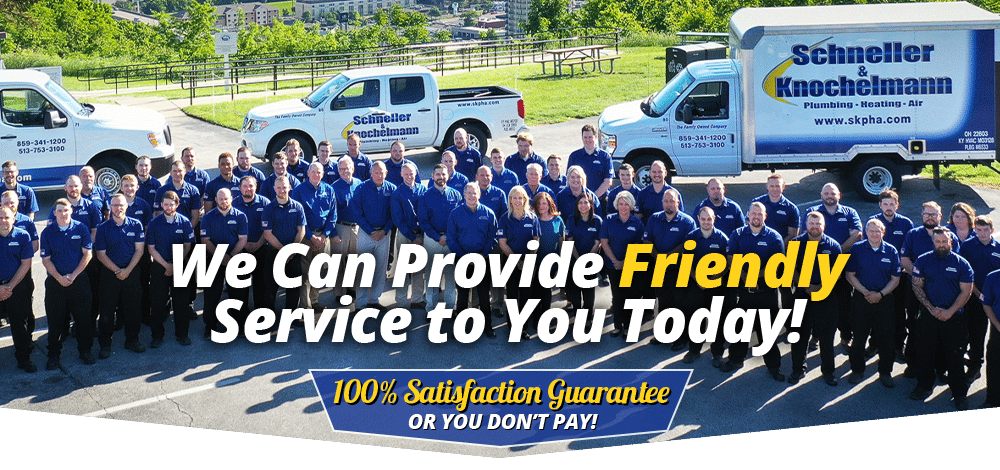 Schneller Knochelmann team standing in front of their trucks. Overlaying text "We Can Provide Friendly Service to You Today! 100% Satisfaction Guarantee or You Don't Pay!"