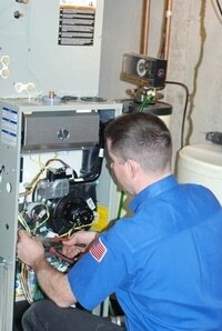 Technician inspecting a furnace system.