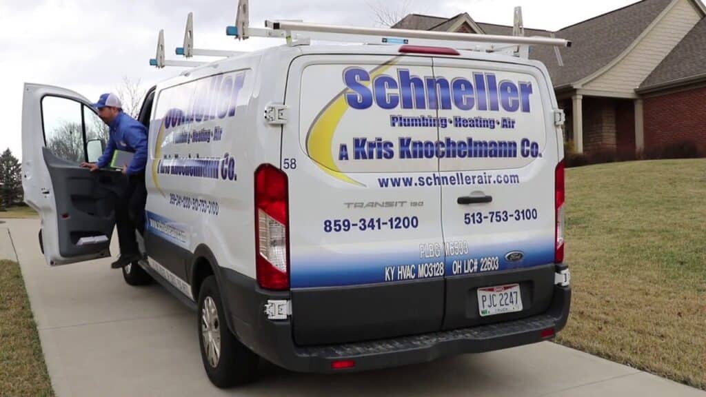 Schneller Knochelmann service van parked in front of a home, with technician getting out of the driver's seat.