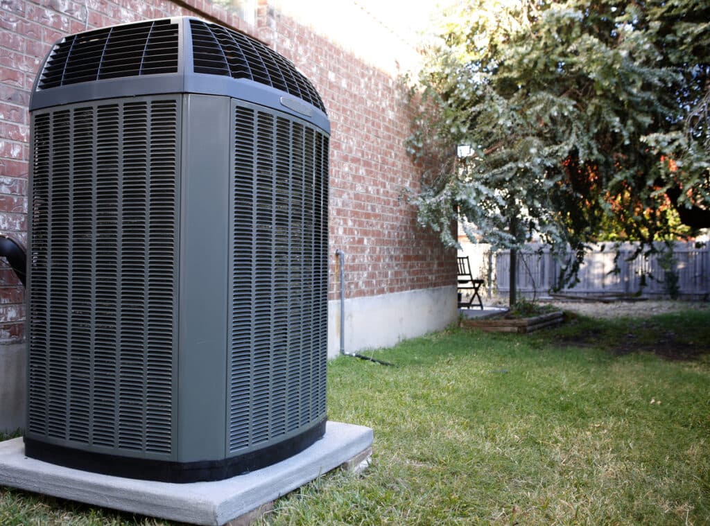 High-efficiency modern HVAC unit outside a brick home