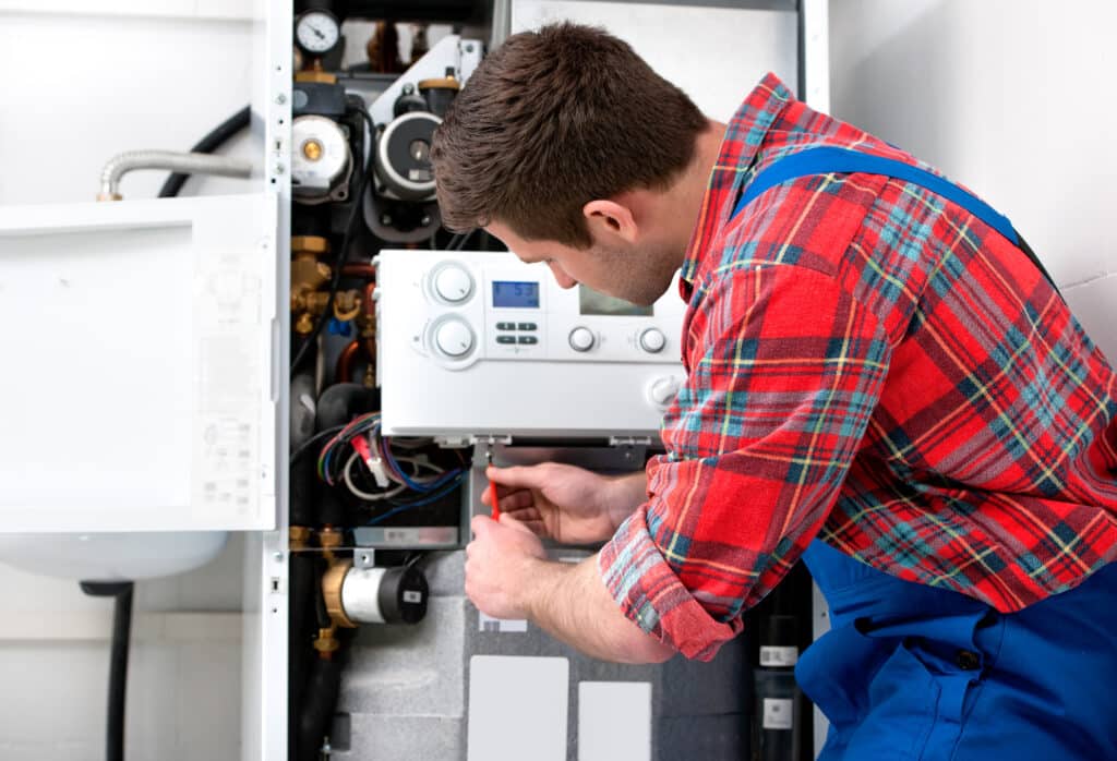 Technician servicing a gas boiler for hot water and heating