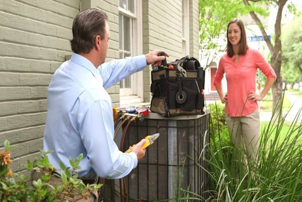 technician servicing an outdoor HVAC unit for residential homeowner